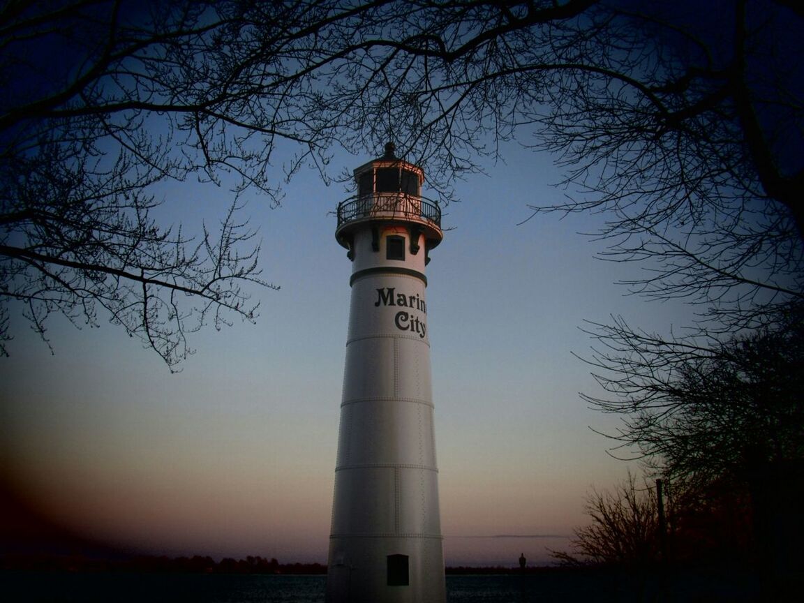 architecture, built structure, building exterior, tower, bare tree, lighthouse, low angle view, guidance, tree, tall - high, sky, protection, direction, branch, security, clear sky, outdoors, safety, no people, travel destinations