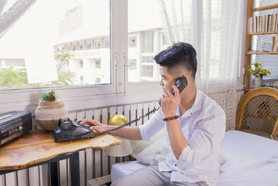 Full length of man using mobile phone at home