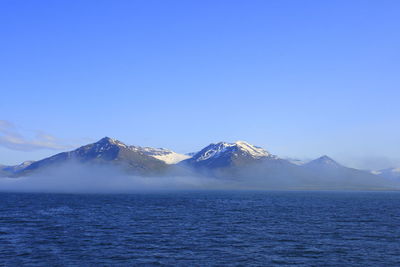 Scenic view of snowcapped mountains against clear blue sky