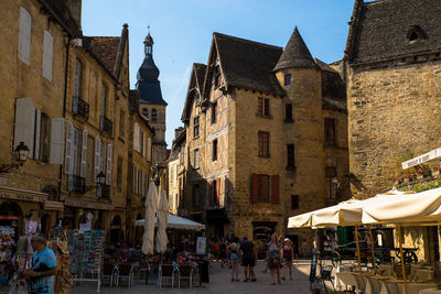 People on street amidst buildings in city