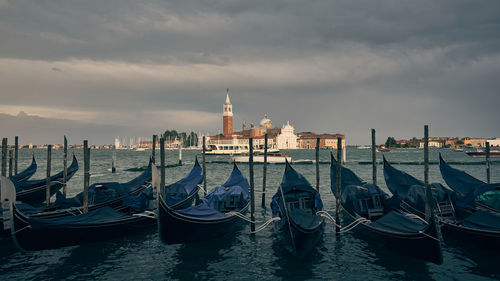 View of buildings at waterfront against cloudy sky