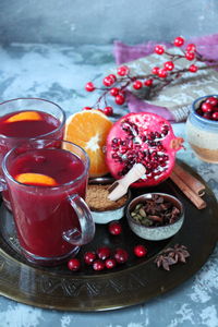 Close-up of fruits in plate by drinks on table