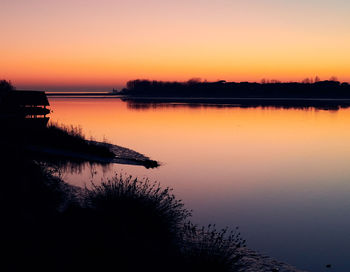 Scenic view of lake against romantic sky at sunset