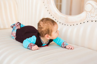 Cute boy lying on bed at home