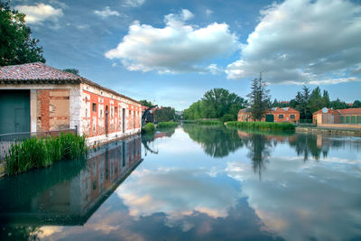 Scenic view of lake by buildings against sky