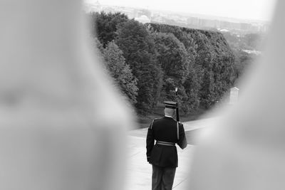 Rear view of man walking on tree