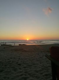 Scenic view of beach against clear sky during sunset