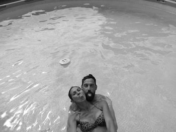 High angle view of smiling couple swimming in pool