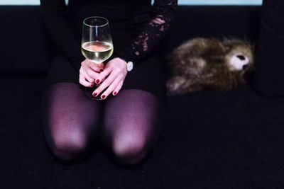 Low section of woman holding drinking glass