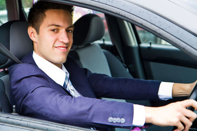 Portrait of young man sitting in car