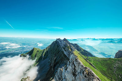 Aerial view of mountains against blue sky