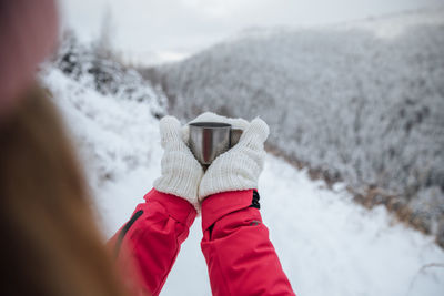 Midsection of woman with snow on mountain