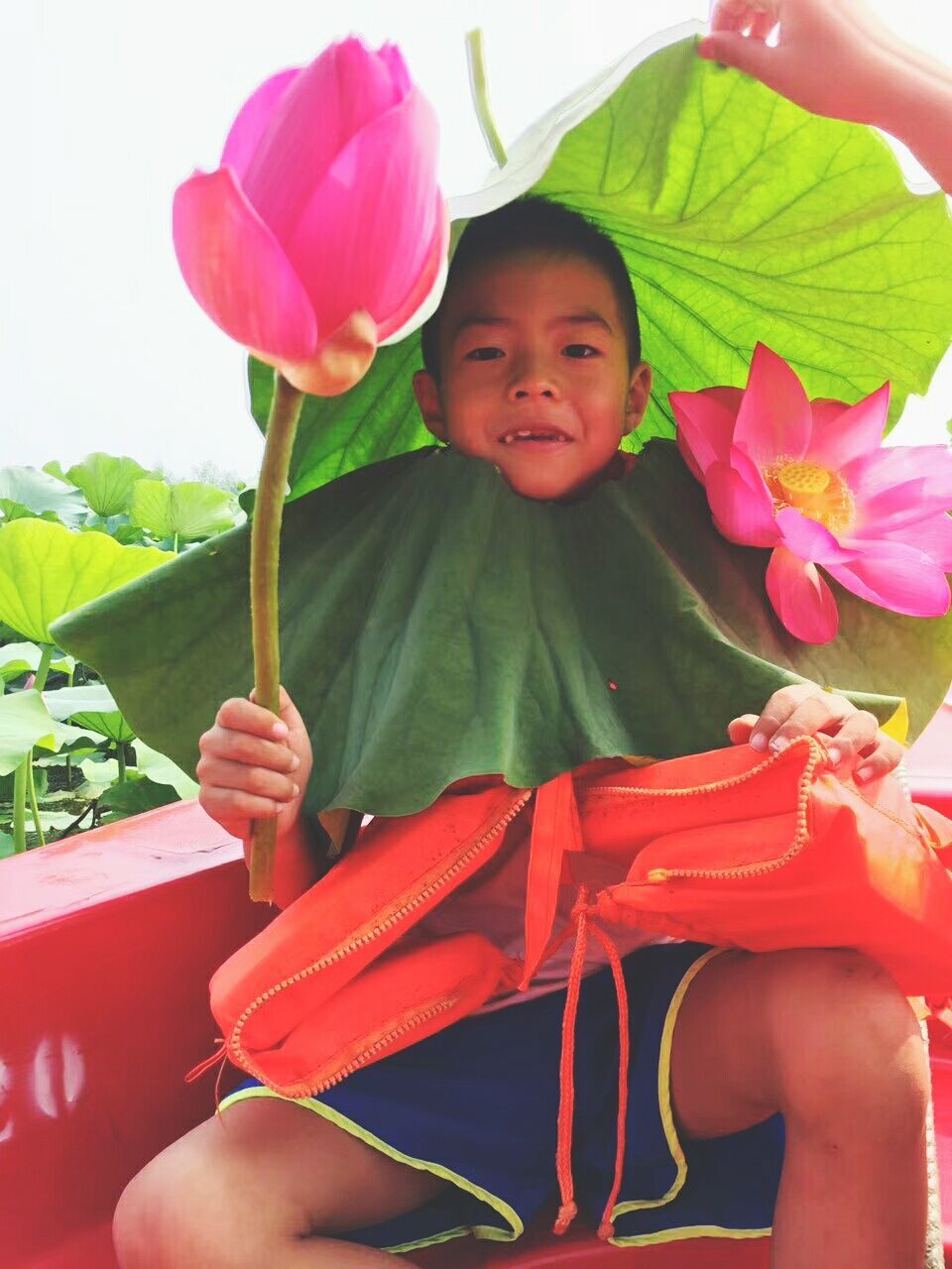 PORTRAIT OF A SMILING GIRL HOLDING PINK FLOWER