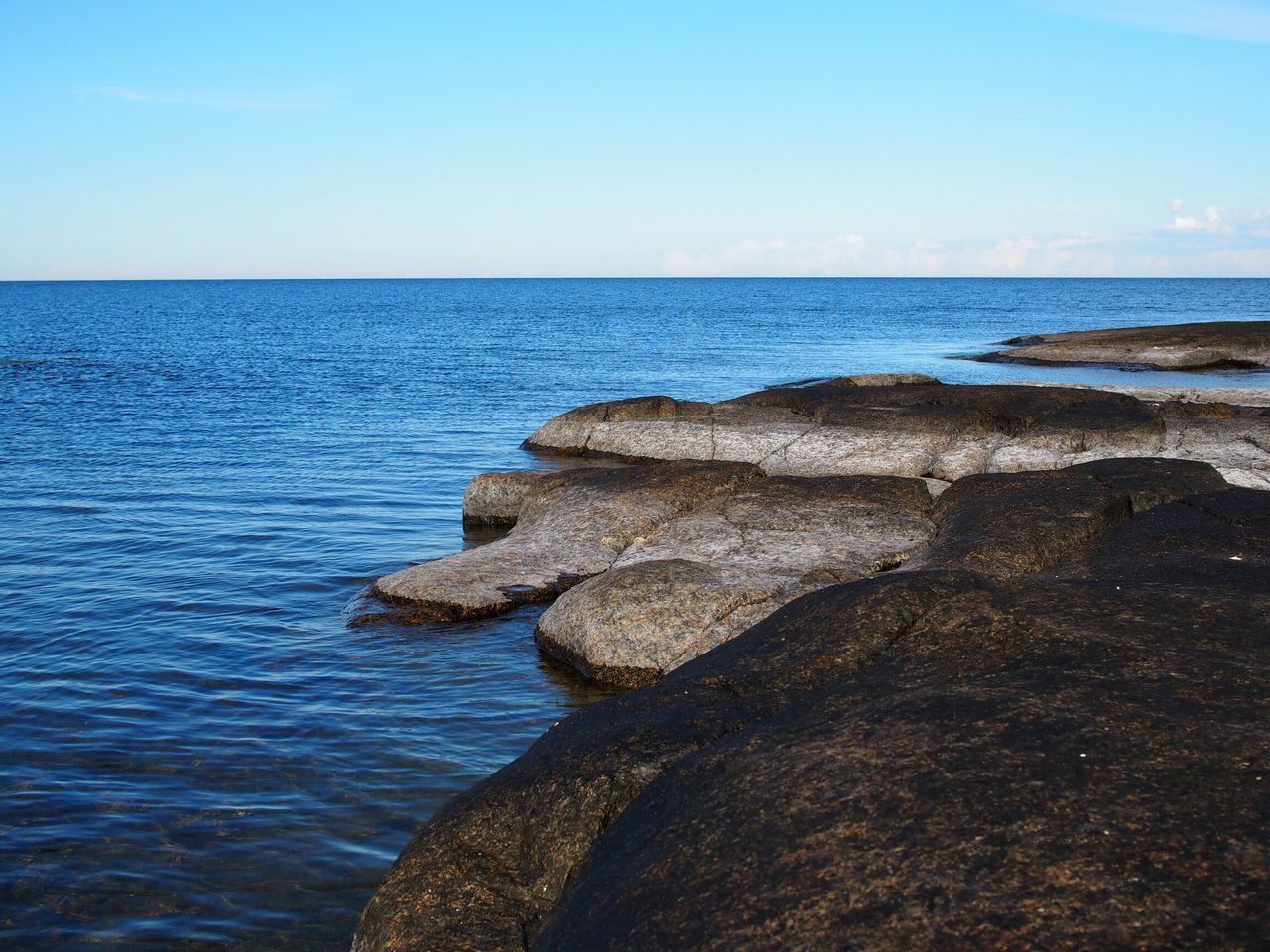 sea, horizon over water, water, tranquil scene, tranquility, scenics, beauty in nature, blue, nature, clear sky, beach, idyllic, sky, shore, rock - object, rippled, seascape, day, calm, copy space