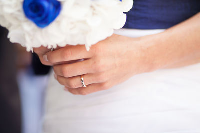 Midsection of bride holding bouquet