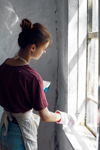 Side view of young woman holding umbrella