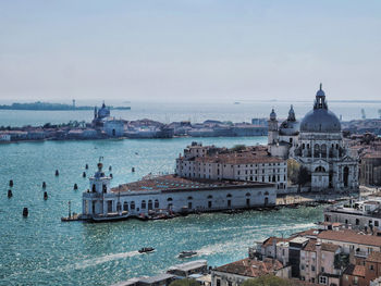 View of buildings by sea against sky