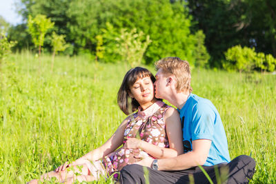 Happy young couple sitting on grass