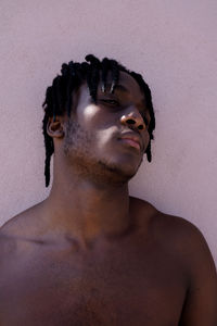 Young black man next to the pink wall portrait