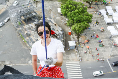 Caucasian woman wearing hero costume descending a tall building in rappel. salvador bahia brazil.