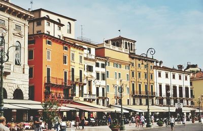 People on street by buildings in city