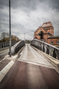 Road by bridge against sky in city