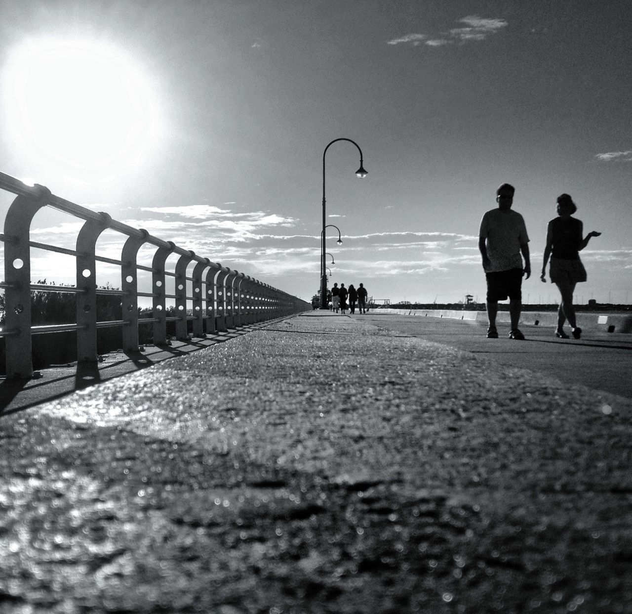 men, lifestyles, leisure activity, walking, sky, person, rear view, full length, silhouette, the way forward, sea, standing, railing, water, sunlight, built structure, beach, tourist