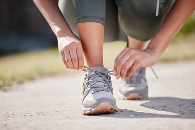 Low section of woman tying shoelace