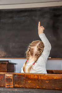 Rear view of woman with arms raised