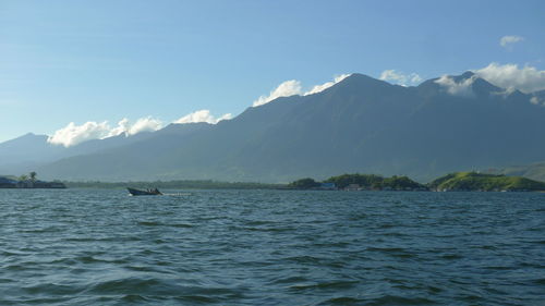 Scenic view of sea and mountains against sky