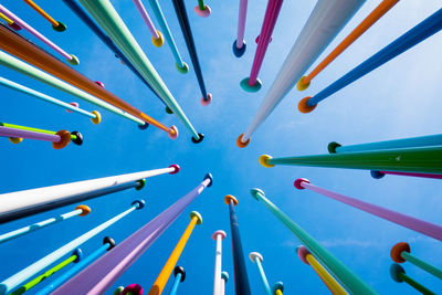 Low angle view of sticks against blue background