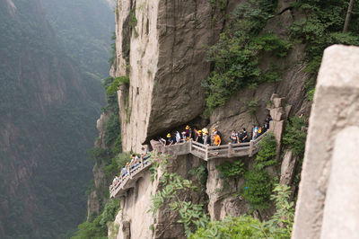 Tourists on steps at huangshan mountain cliff