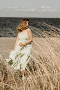 Side view of woman sitting at beach