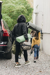 Family unloading luggage from electric car