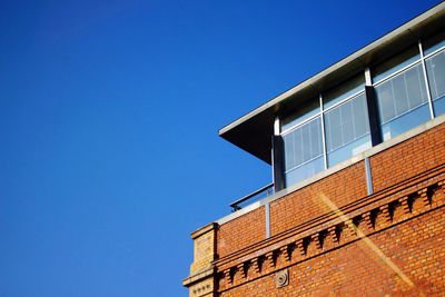 Low angle view of buildings against clear blue sky