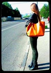 Rear view of woman walking on road