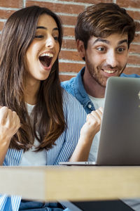 Portrait of young woman using laptop at table