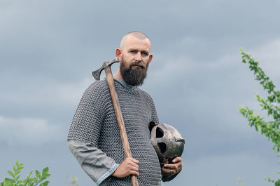 Ax in the hands of medieval viking warrior. metal chain mail. side view. filming historical film.