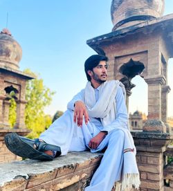 Low angle view of man sitting on roof