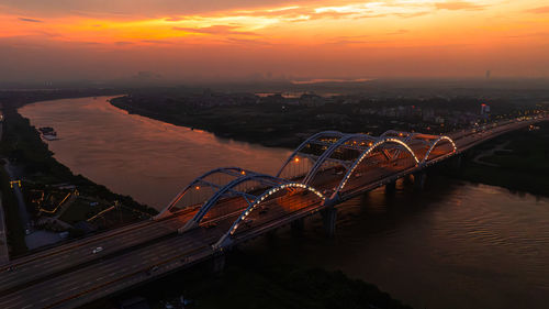 Bridge over river against sky during sunset
