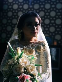 Portrait of young woman holding flower bouquet