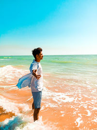 Full length of man standing on beach against sky