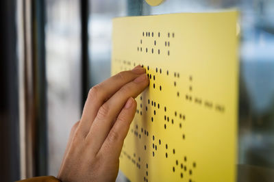 Cropped hand of blind woman reading