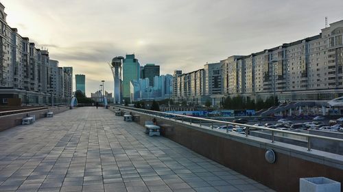 View of city street against cloudy sky