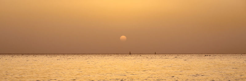 Scenic view of sea against orange sky
