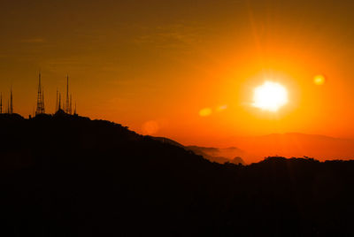 Scenic view of silhouette mountains against orange sky