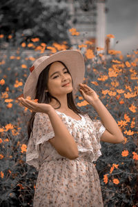 Young woman wearing hat against plants during autumn