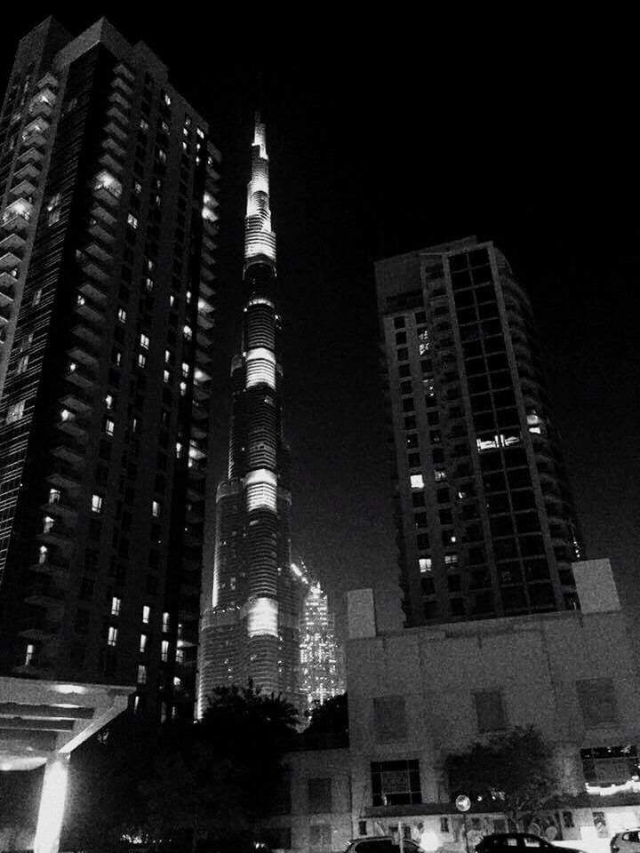 LOW ANGLE VIEW OF ILLUMINATED SKYSCRAPERS AGAINST SKY