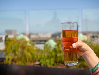 Close-up of hand holding beer glass