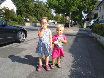 Full length portrait of happy girl on road